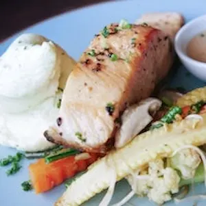 baked salmon shown with mashed potatoes and mixed vegetables